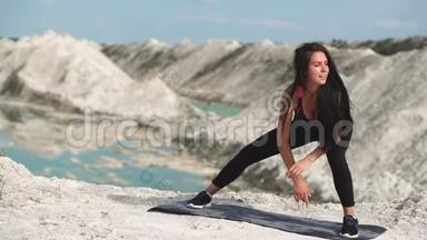 穿着黑色运动服<strong>的</strong>运动型黑发女孩在一个蓝水白垩沙场上训练。 从<strong>表演</strong>卷<strong>开始</strong>